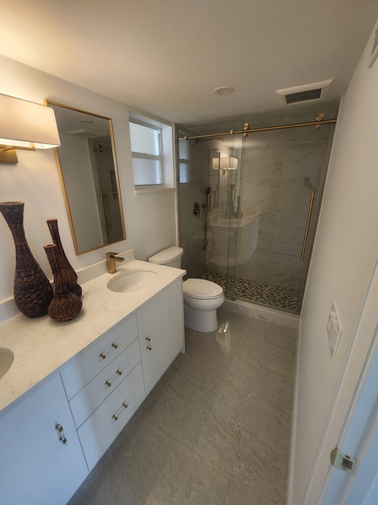 A clean bathroom featuring a shower, toilet, and sink, designed for functionality and comfort.