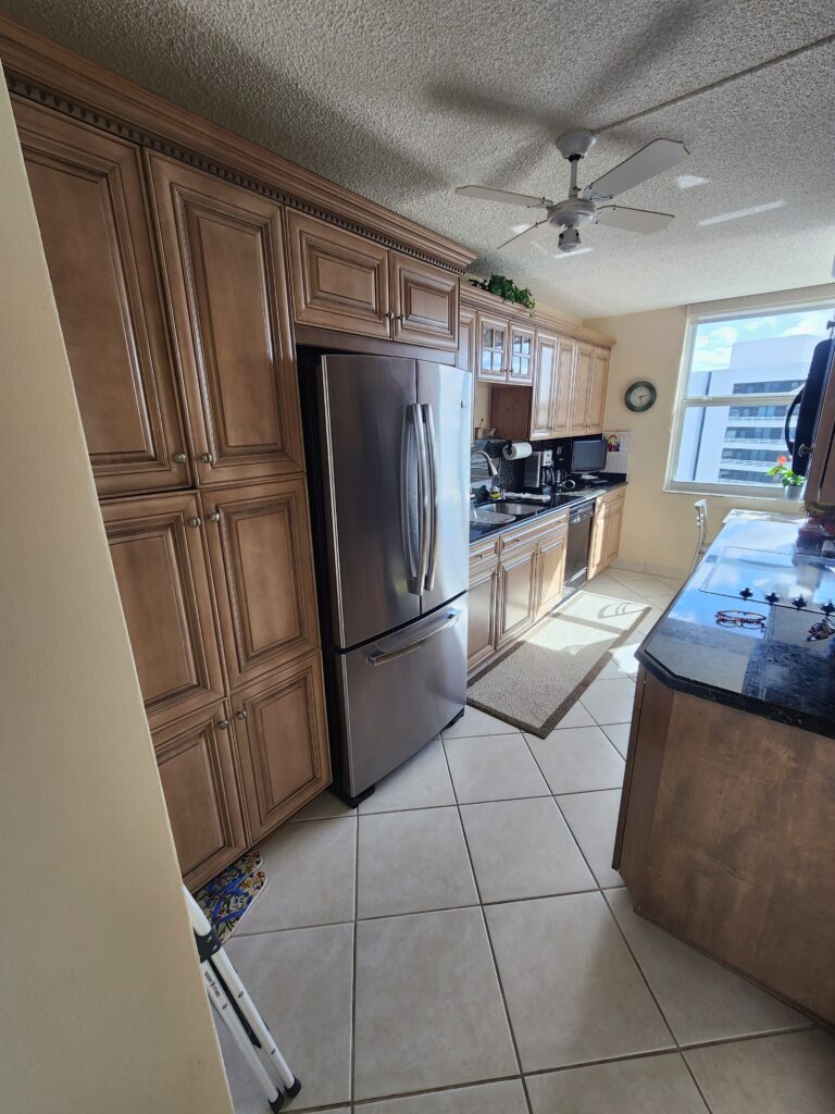 A modern kitchen featuring a refrigerator, stove, and cabinets, showcasing a functional and organized cooking space.