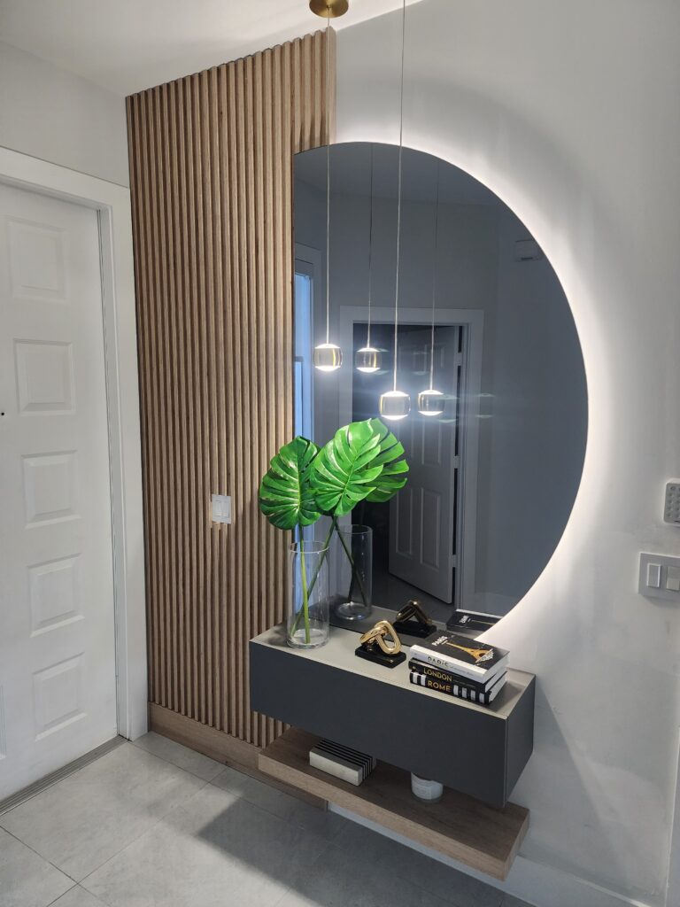 . A contemporary foyer featuring a stylish mirror and a vibrant plant, creating an inviting atmosphere.