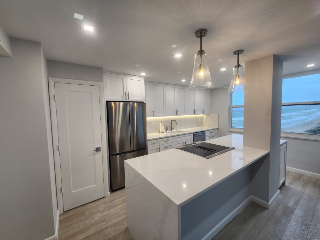 A modern kitchen featuring white cabinets and a spacious central island, creating an inviting cooking space.
