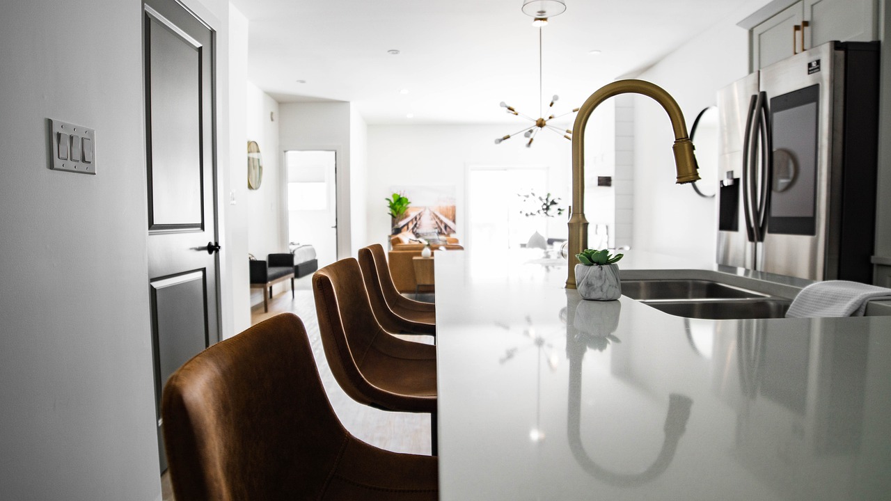 A modern kitchen featuring a sink, refrigerator, and a stylish bar area for dining and entertaining.